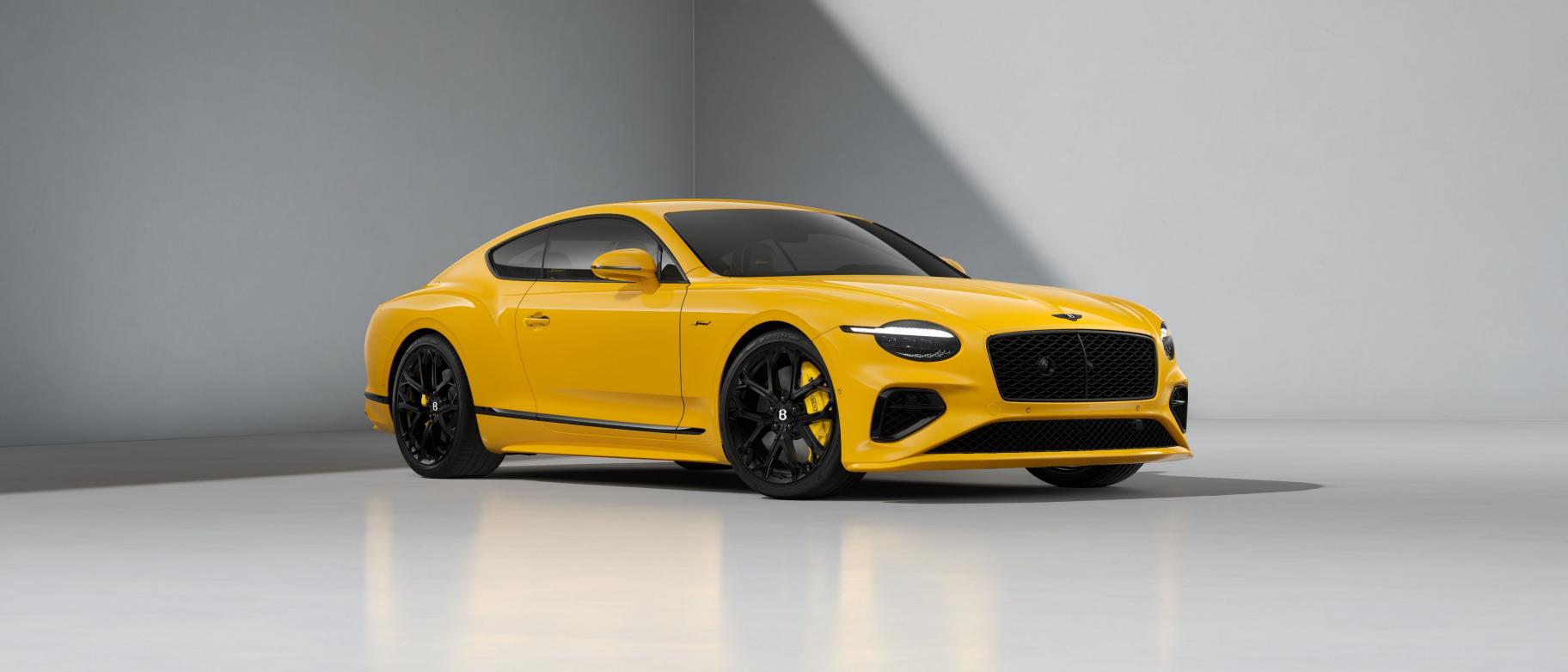 Bentley Continental GT Speed plug-in hybrid grand tourer in dark green, front three-quarter view on a country road