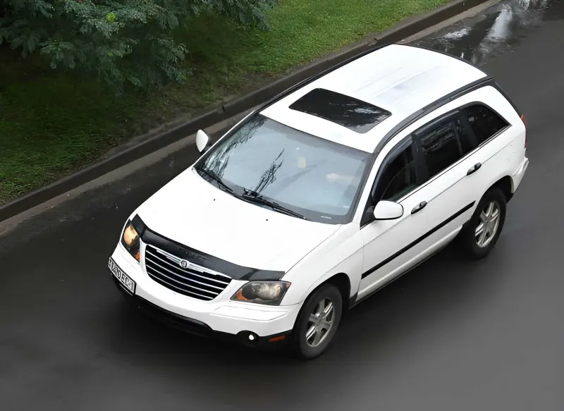Chrysler Pacifica Hybrid plug-in minivan in white, front angle view in a parking garage