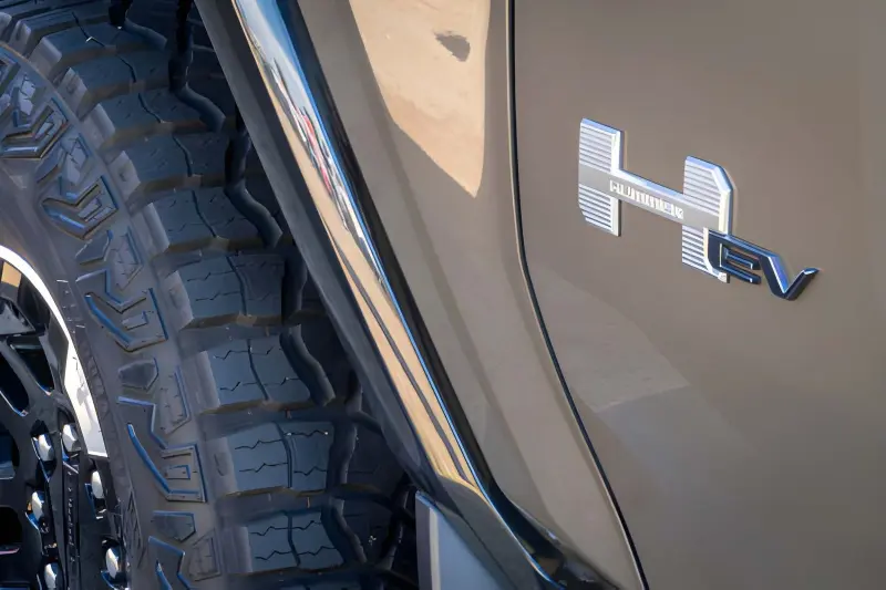 Close-up detail of the 2026 GMC Hummer EV front grille and illuminated badge